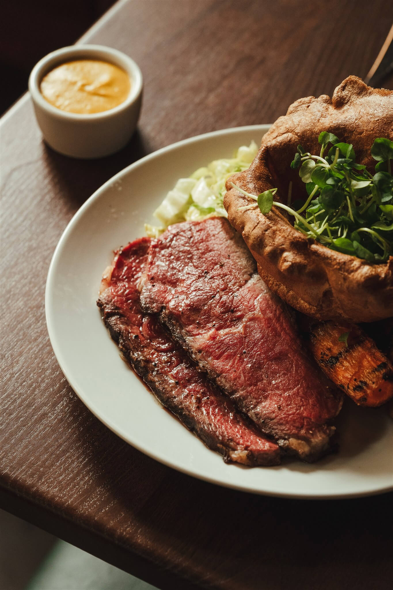 Sliced roast beef with a Yorkshire pudding and mustard