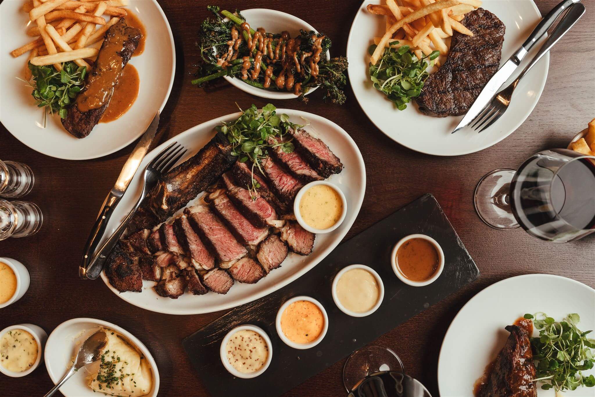 A spread of MRBL steaks, sides and house sauces